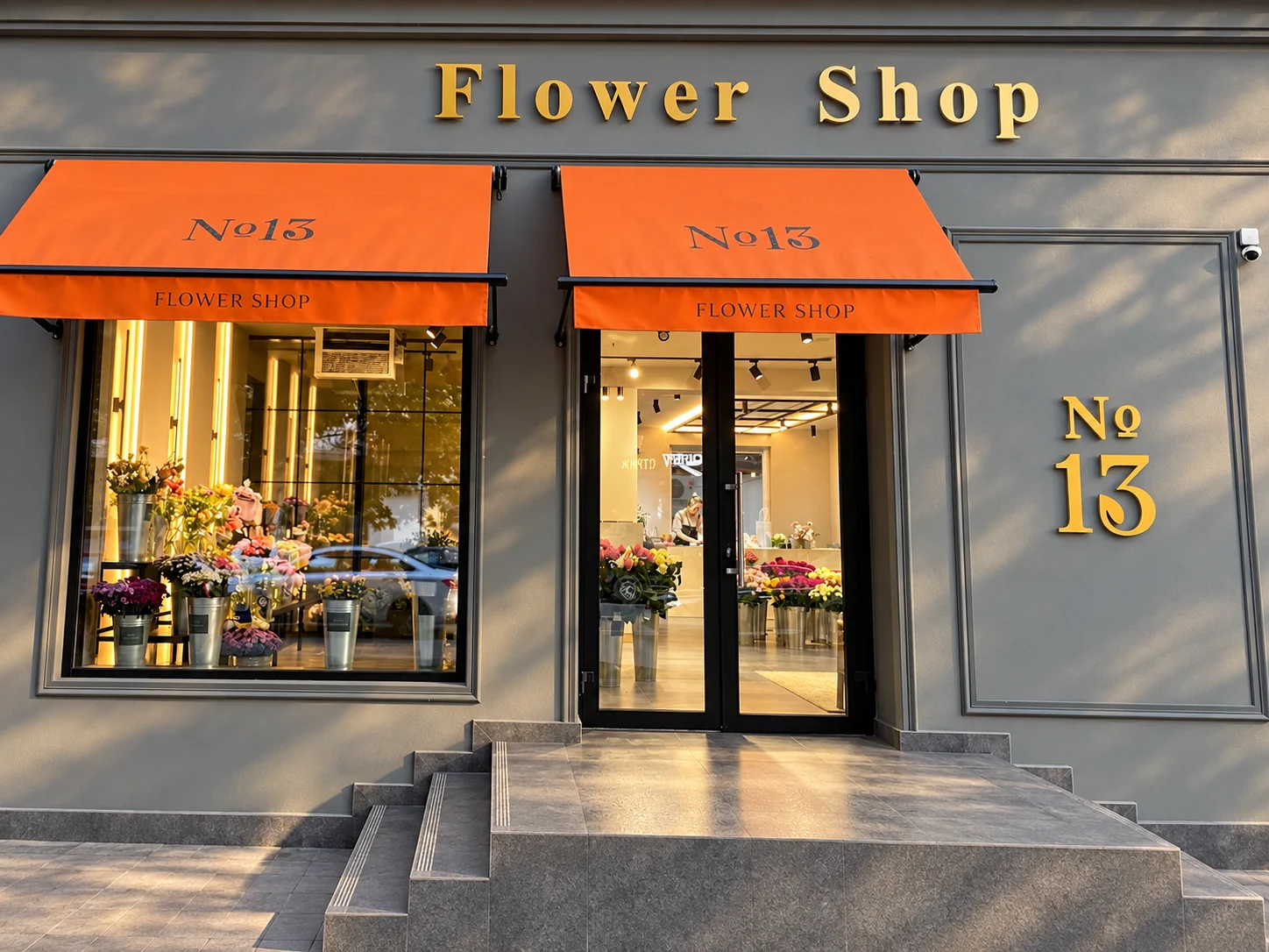 Фасад Flower shop 13: графитовые стены, оранжевые маркизы и золотая вывеска